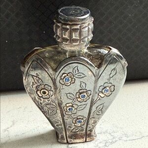 Vintage heart-shaped perfume bottle casing floral engravings